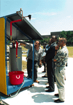 Photo of John Harrison showing solar thermal demonstration to visitors.