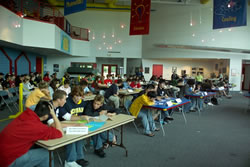 Photo of participants at tables for preliminary elimination rounds.