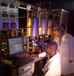 Photo of two scientists with aparatus in laboratory.